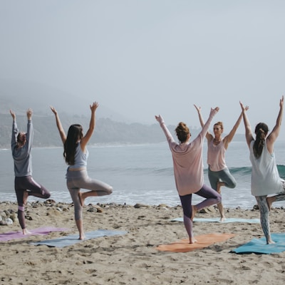 Group yoga on the beach at sunset